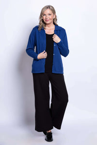 Woman standing in royal blue Lily Cardigan and wide-leg black pants, smiling