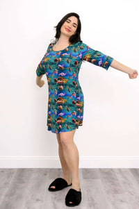 Woman stretching joyfully in a bamboo sleepshirt with an ocean-inspired print
