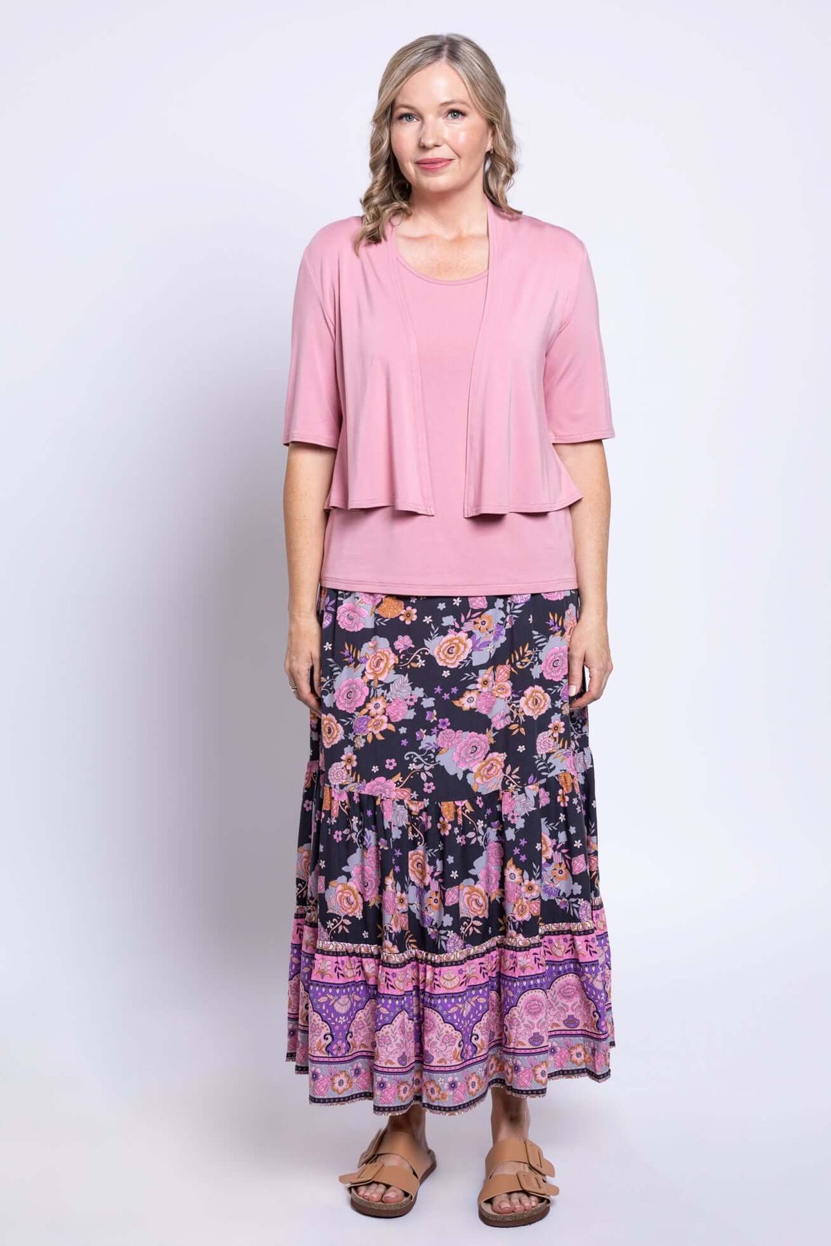 Woman styled in Tibby floral maxi skirt, pink tank top, and matching pink cardigan