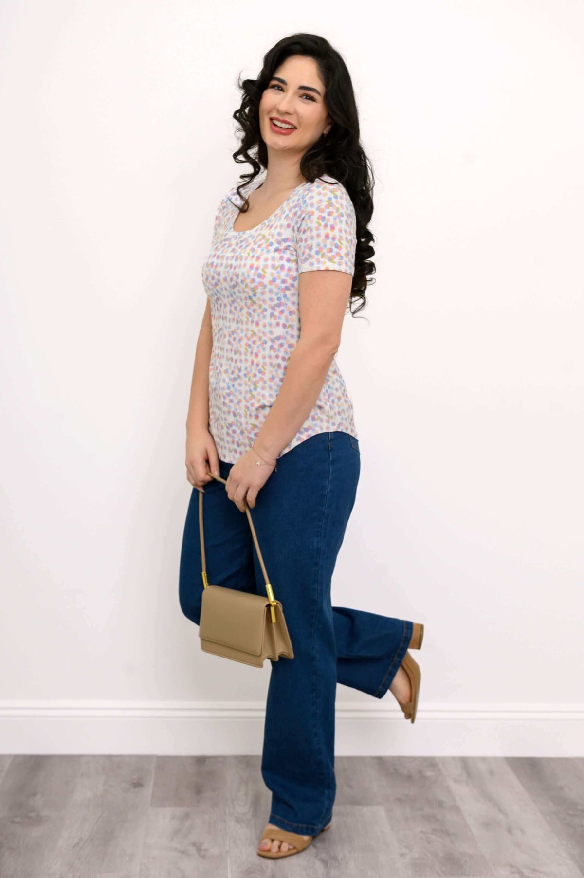 Full-length view of woman in Tessa Tee, blue jeans, tan purse and sandals