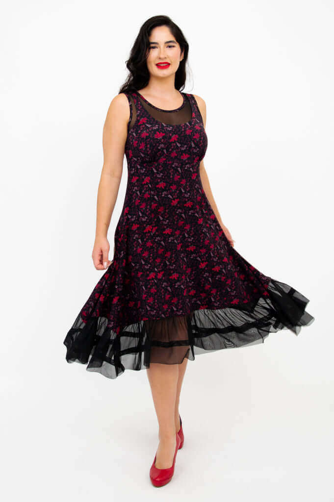 Woman twirling in sleeveless floral A-line dress with mesh hem