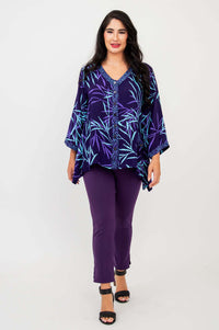 Woman walking in purple bamboo print tunic, matching purple pants, and black sandals