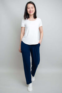 Woman wearing Clair Bamboo Pants and a white tee, standing and smiling