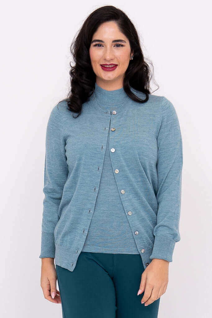 Woman wearing a blue Merino wool crew neck cardigan with button-up detail