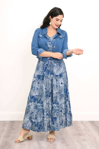 Woman wearing a blue denim jacket over a blue floral tiered maxi skirt