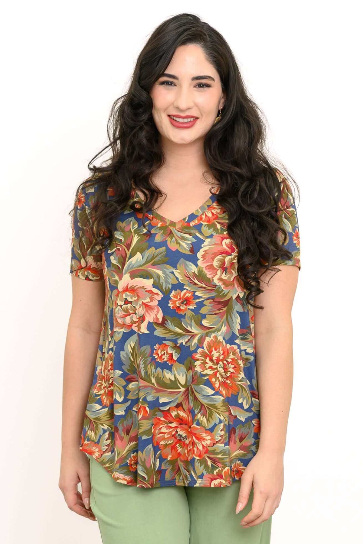 Woman wearing a blue floral bamboo top with v-neck and short sleeves, smiling