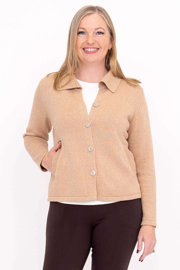 Woman wearing a hip-length beige cardigan with a collared neckline
