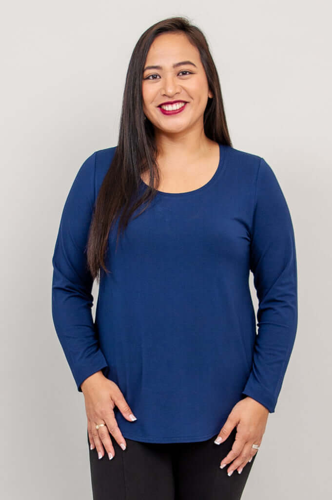Woman wearing a navy blue long sleeve scoop neck top, front view