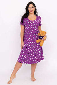 Woman wearing a purple polka dot sleepshirt holding a teddy bear