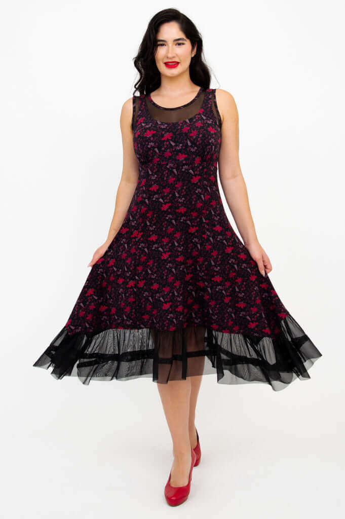 Woman wearing a sleeveless A-line dress with mesh hem and floral pattern