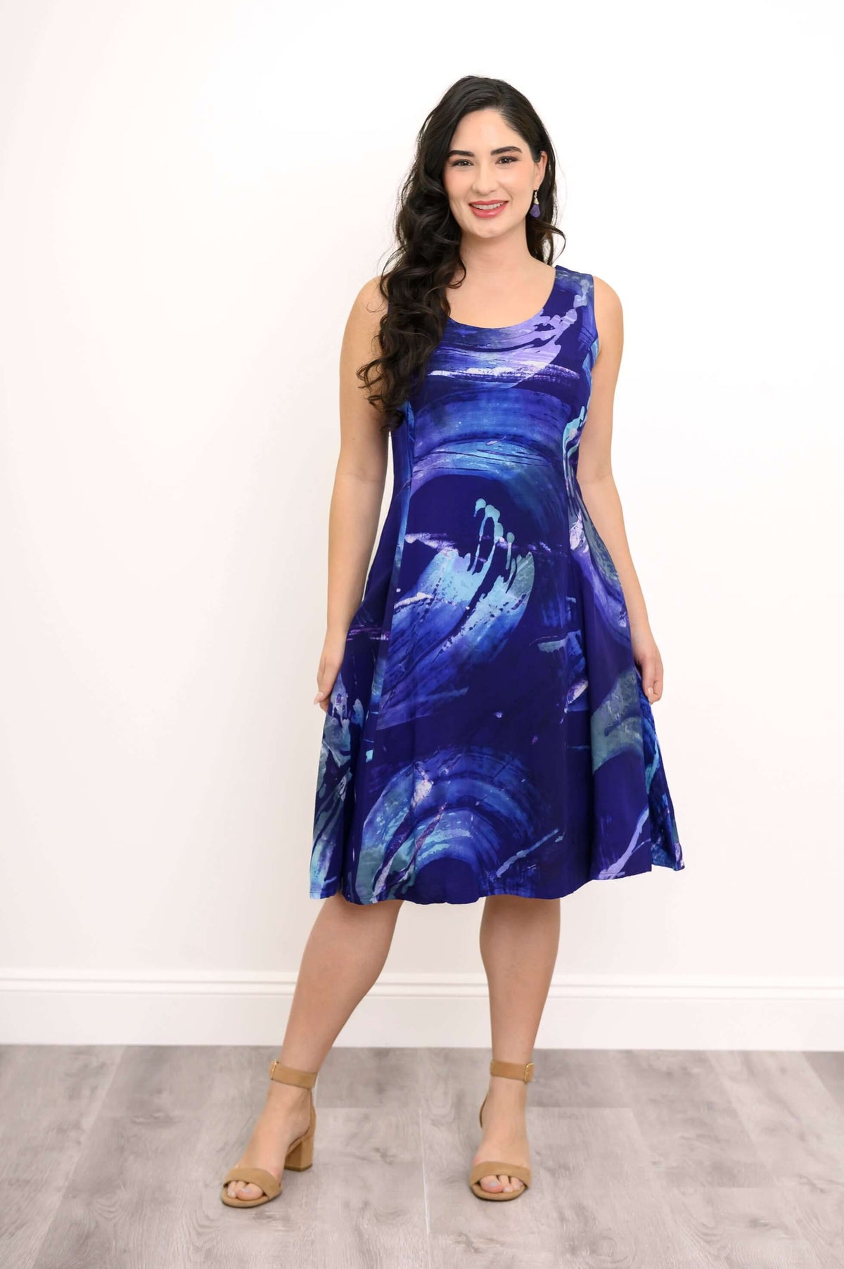 Woman wearing a sleeveless knee-length dress with blue abstract swirl print
