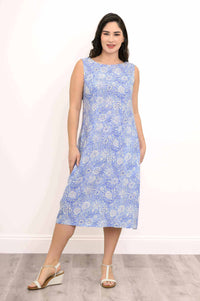 Woman wearing a sleeveless light blue floral midi dress standing on wood floor