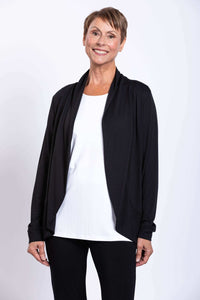 Woman wearing a black French Terry jacket over a white top and black pants, smiling