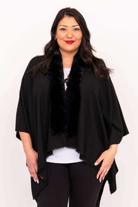 Woman wearing a black wrap with faux fur collar, facing forward
