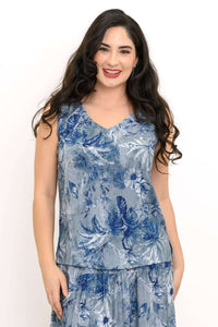 Woman wearing a blue floral V-neck tank top with wide shoulder straps, smiling