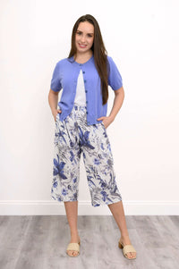 Woman wearing blue floral capri pants with a light blue cardigan and sandals