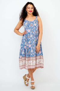 Woman wearing a sleeveless blue floral midi dress with an A-line skirt