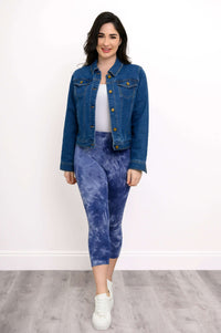 Woman wearing blue tie-dye capri leggings with a denim jacket and white sneakers