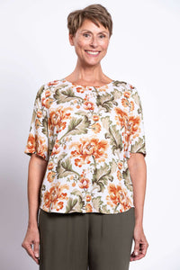 Woman smiling in a floral bamboo-linen blouse with elbow sleeves, front view