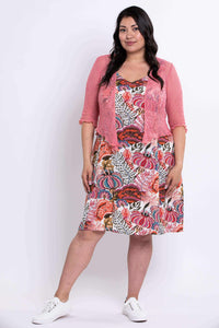 Woman wearing floral dress paired with a pink short cardigan