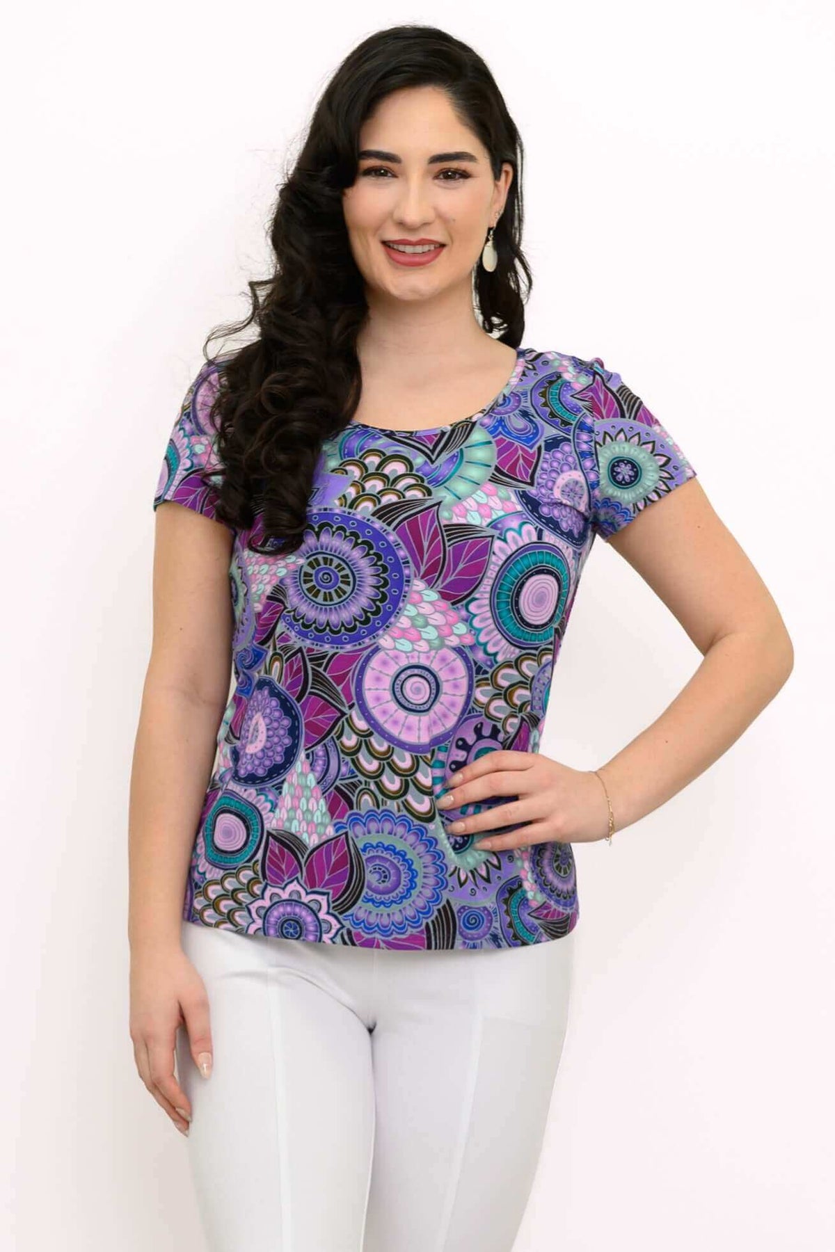 Woman wearing a purple mandala-patterned bamboo top with white pants, front view
