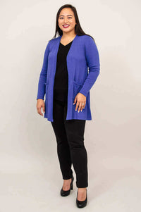 Woman wearing a royal blue open-front cardigan sweater with front pockets