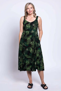 Woman wearing a sleeveless black dress with green leaf print and pockets