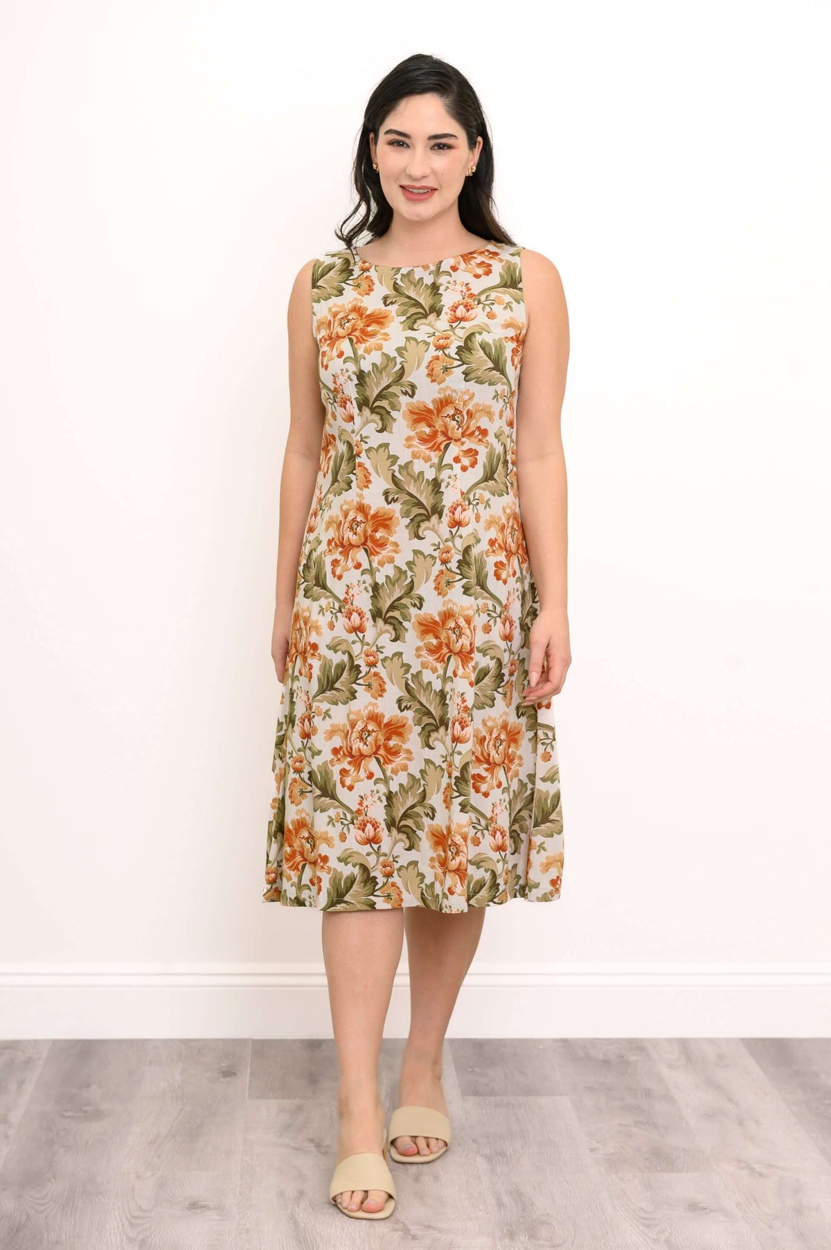 Woman wearing sleeveless floral midi dress with side pockets