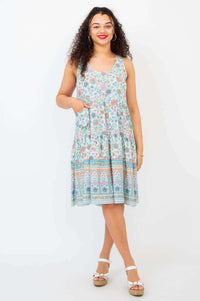Woman wearing sleeveless floral patterned tiered dress with scoop neckline