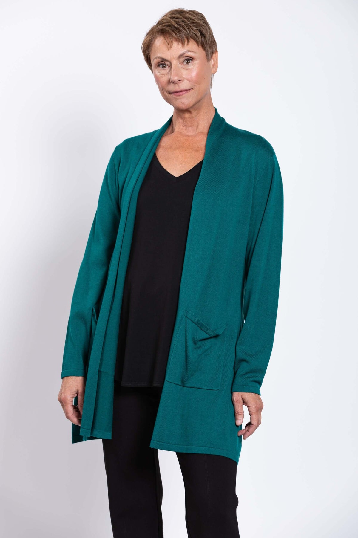 Woman wearing teal open front cardigan over black top and pants