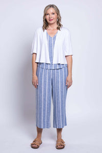 Woman in white short sleeve cardigan over blue striped sleeveless top and capri pants