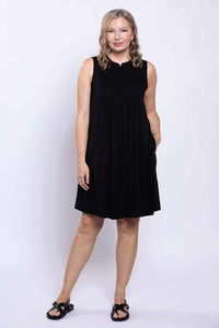 Woman with hand in pocket modeling black sleeveless A-line dress