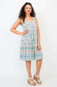 Woman with hand on hip modeling floral Kayana dress