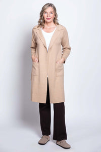 Woman posing with hands in the pockets of a beige open front cotton jacket