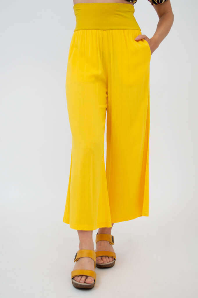 Yellow wide-leg cropped capri pants with deep waistband, front view closeup