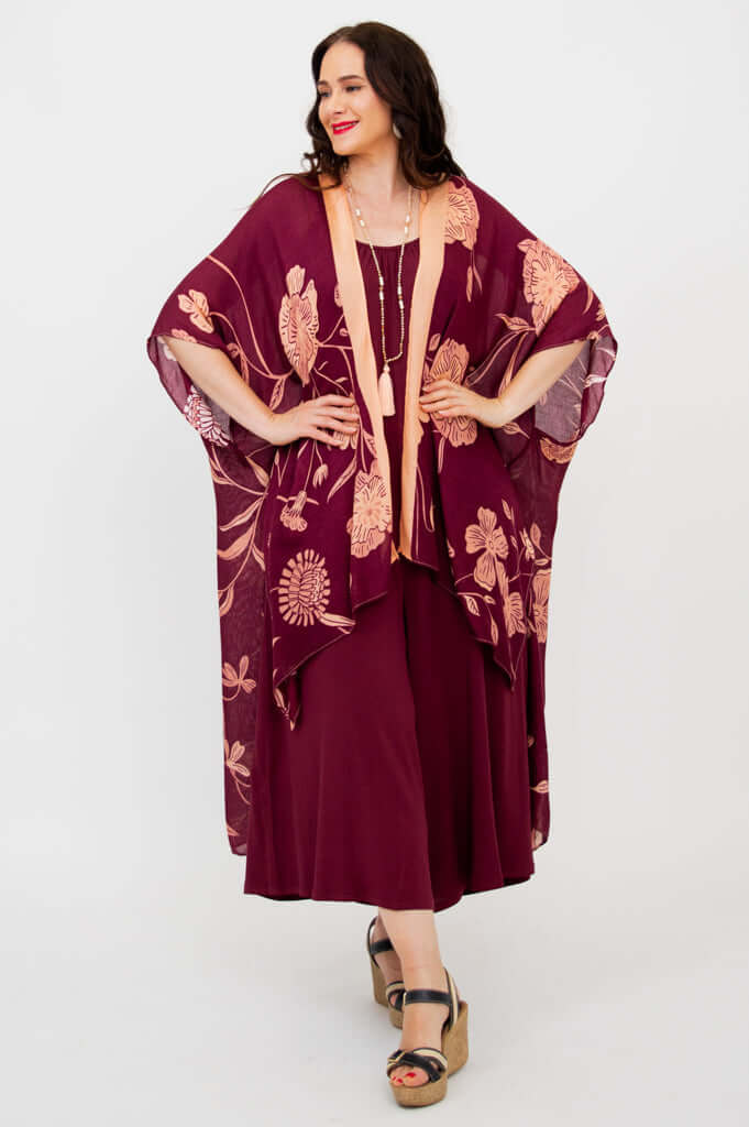 Side and front view of woman in burgundy floral kimono wrap with peach edging