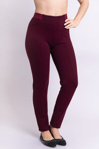 Hand on the hip view of women's petite burgundy tailored pant, with slim and narrow leg. Made of sustainable and natural bamboo fibers, fair-trade.